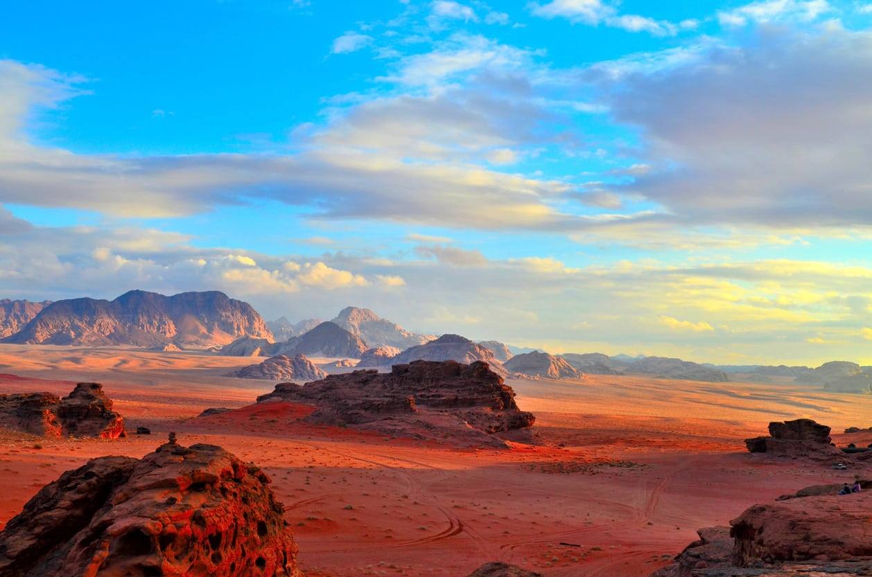 Paysage spectaculaire du désert de Wadi Rum avec ses falaises rouges et son sable doré.