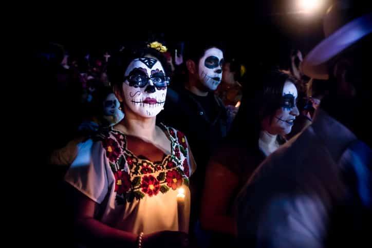 Un autel traditionnel du Dia de los Muertos au Mexique, richement décoré de fleurs orangées, de bougies et de têtes de mort en sucre.
