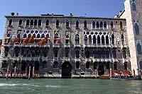 Façade d'un palais vénitien éclairé à la tombée de la nuit sur le Grand Canal