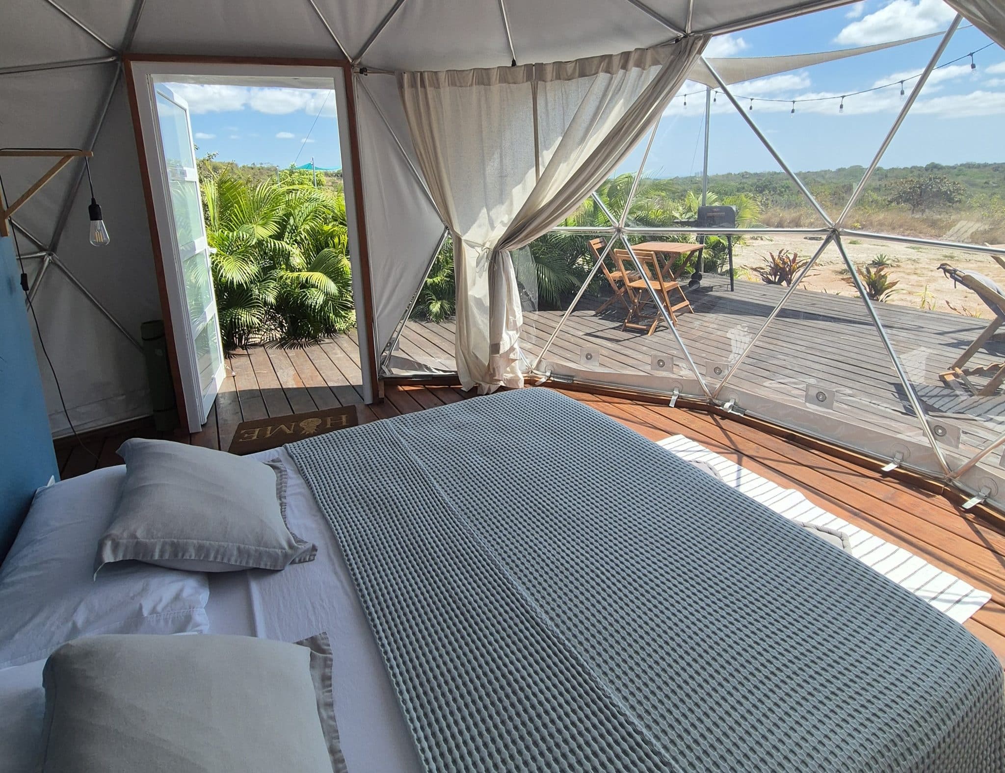Vue extérieure d'un dôme géodésique transparent du Prana Home entouré par la forêt tropicale au Panama