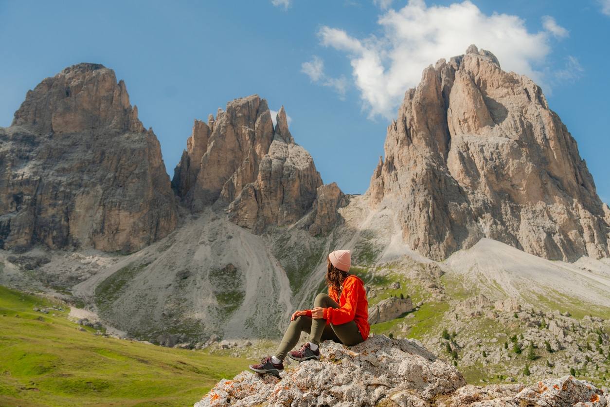 Randonneurs sur un sentier face aux falaises calcaires des Dolomites en Italie.