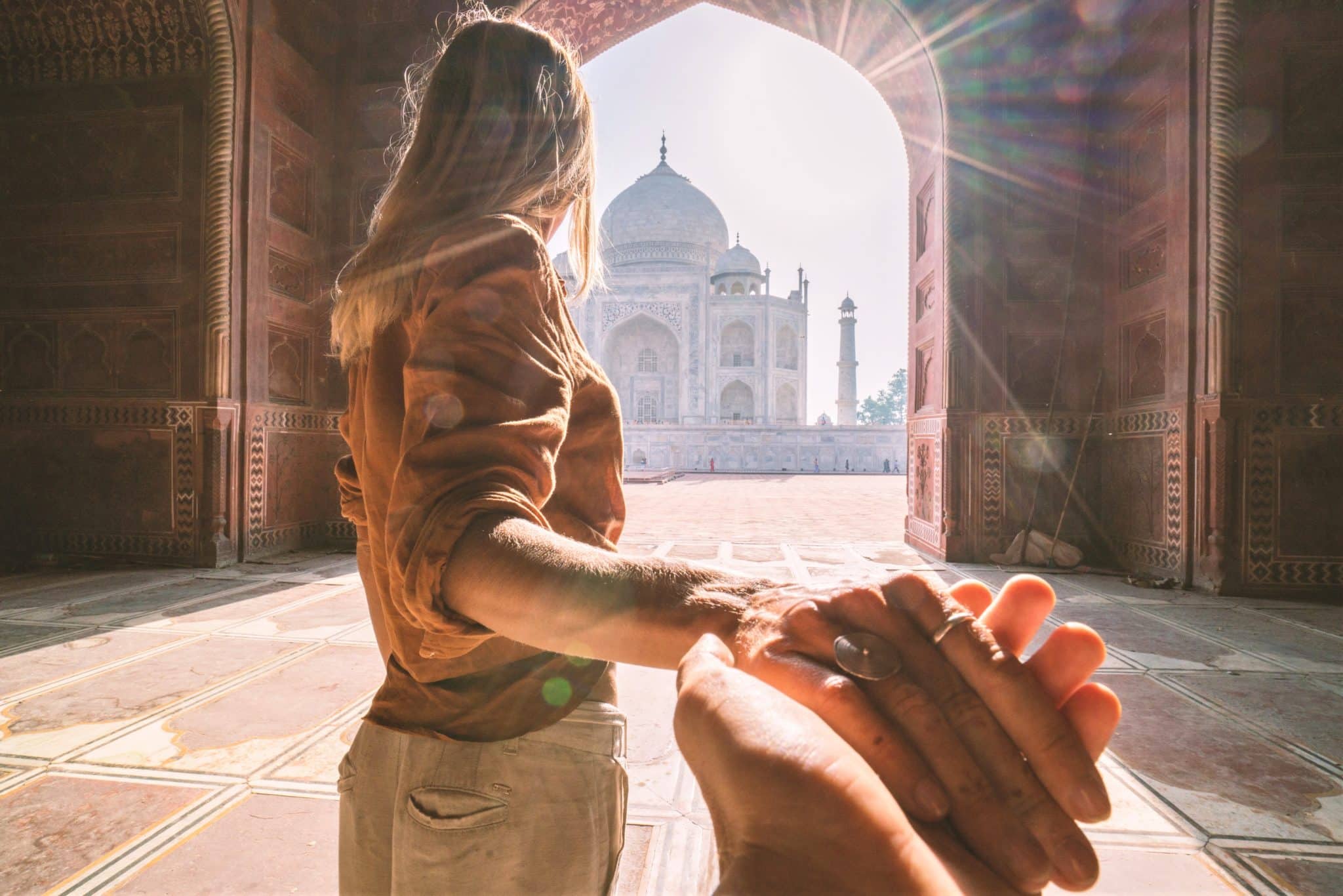 Une touriste conduit son petit ami au magnifique et célèbre mausolée d'Agra, le Taj Mahal.
