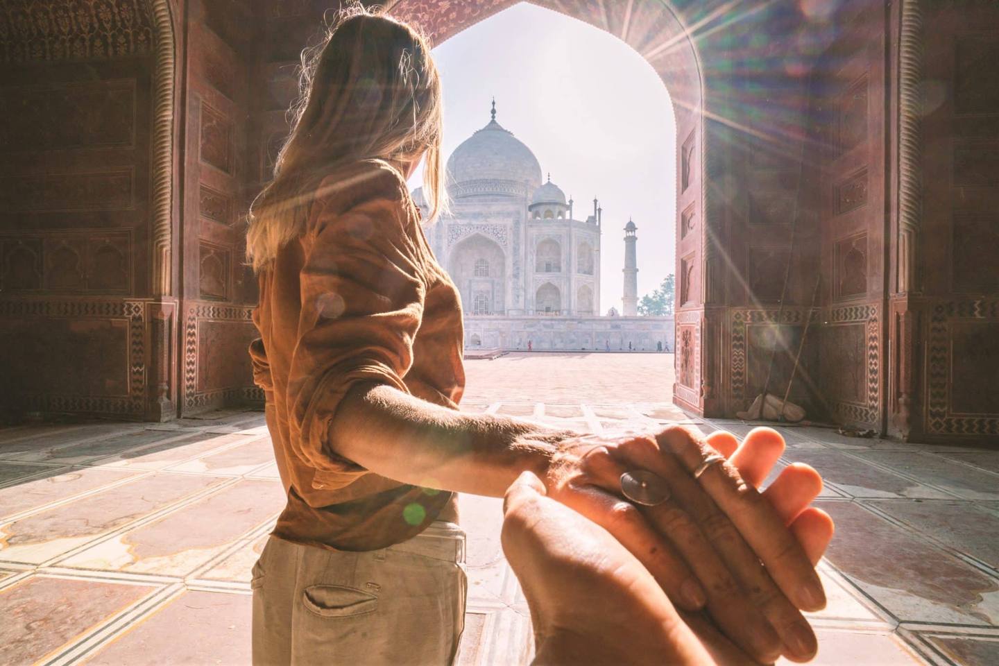 Une touriste conduit son petit ami au magnifique et célèbre mausolée d'Agra, le Taj Mahal.