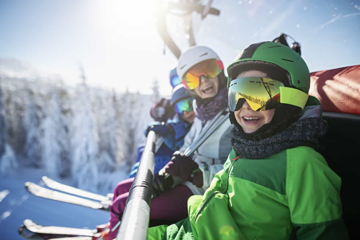 Skieurs descendant une piste enneigée face aux sommets des Alpes du Nord en Savoie