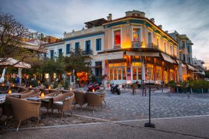Place avec des restaurants dans le quartier d'Athènes Thissio à la tombée de la nuit