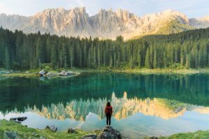 Femme qui contemple le lac Carezza, dans les Dolomites