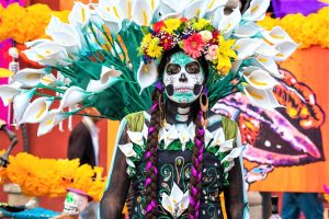 Portrait d'une femme maquillée en squelette et décorée de fleurs à l'occasion de la fête des morts au Mexique : incontournables du Mexique