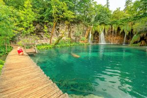 Fille sur la jetée de la cascade Galovacki Buk du parc national des lacs de Plitvice en Croatie dans la région de Lika. Patrimoine mondial de l'UNESCO de la Croatie nommé Plitvicka Jezera.
